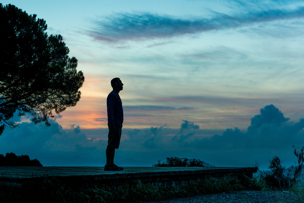 A person facing emotional shadows, representing the inner conflict between self-compassion and self-criticism.